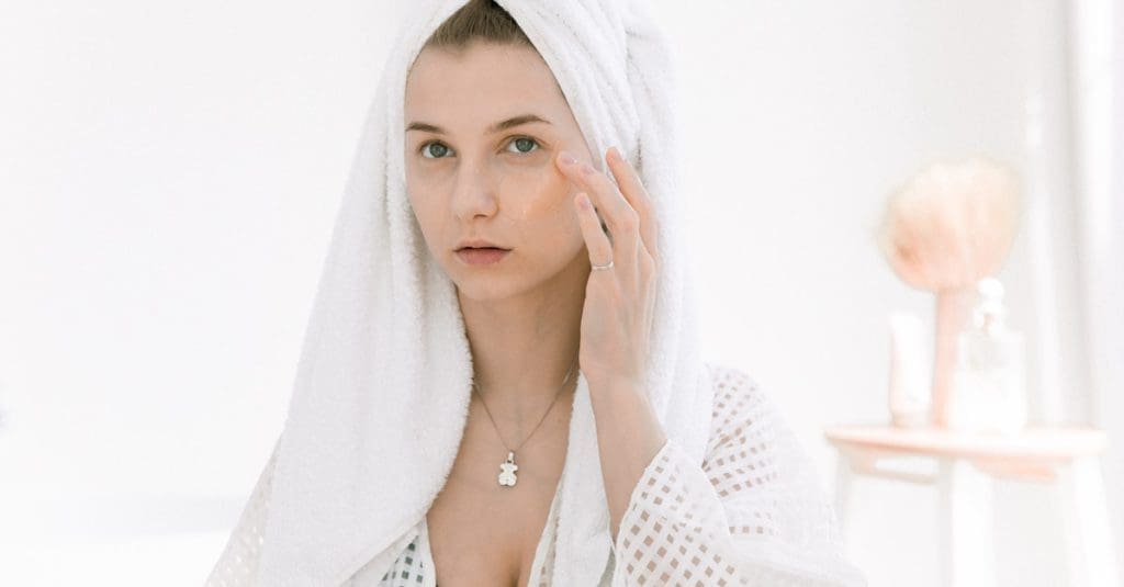 This image shows a woman applying CBD on dry skin.